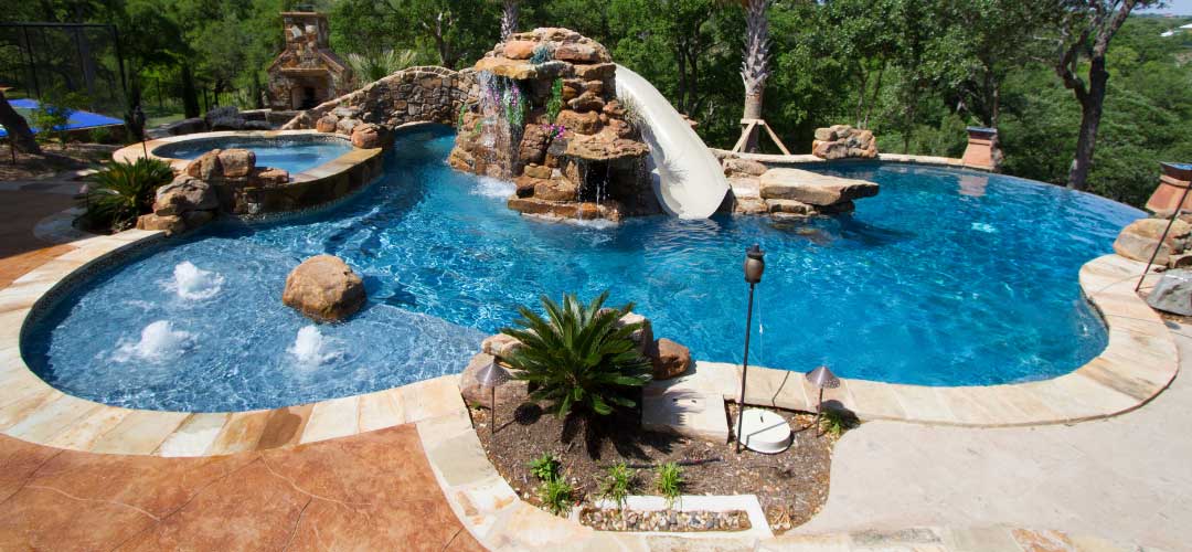free form pool with waterslide, bubblers, spillover spa, infinity edge