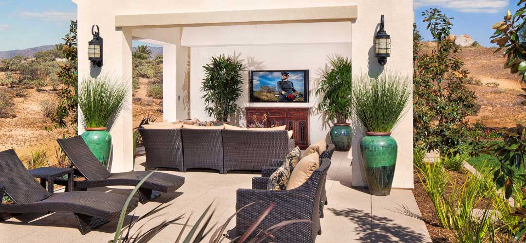 covered patio with outdoor television in desert backyard