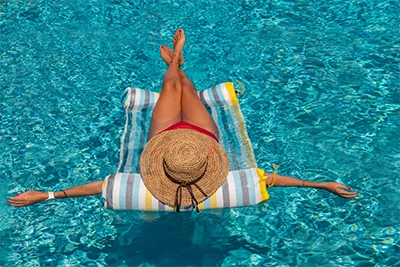 woman lounging in pool on float