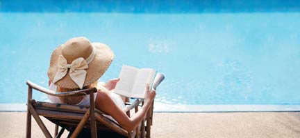Woman Reading Book, While Lounging at the PoolPoolside